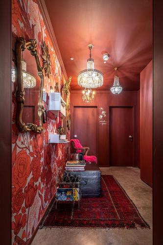 a hallway with a red wall with a mirror at toctoctoc lisboa in Lisbon