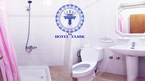 a white bathroom with a toilet and a sink at HOTEL TARIK Fnideq in Fnidek