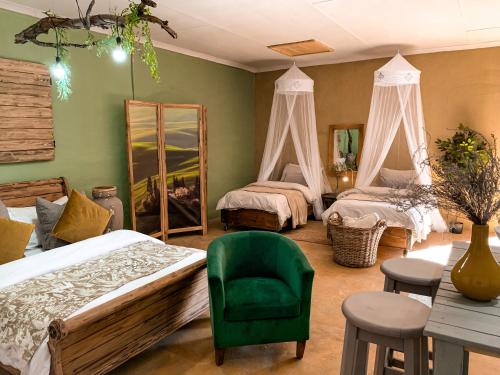 a bedroom with two beds and a green chair at Lush in Graskop