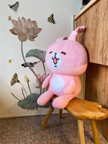 a pink teddy bear sitting on a chair in a room at Forrest Cafe Villa in Jian