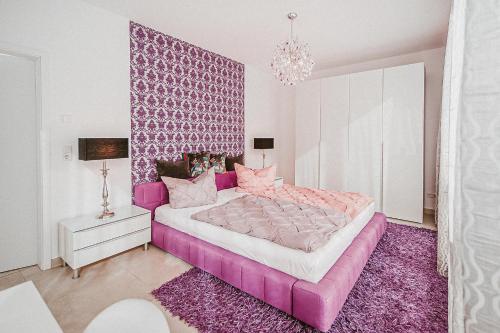 a bedroom with a pink bed with a purple headboard at Villa Baldursheim in Zinnowitz