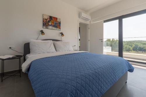 Un dormitorio con una cama con un edredón azul. en Villa Luna Fiorini by SeeAdria, en Brtonigla