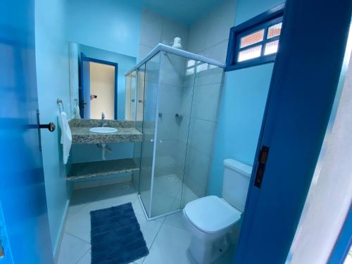 a bathroom with a shower and a toilet and a sink at Pousada Nossa Casa in Itaúnas