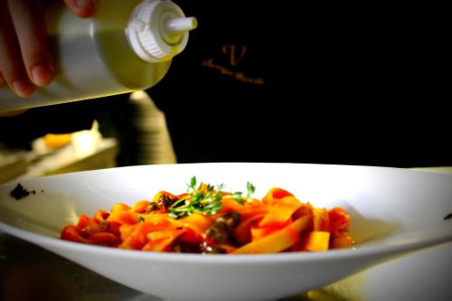 a person pouring food into a white bowl of food at Vincci Soma in Madrid