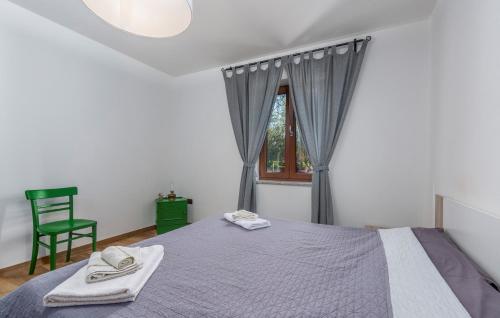a bedroom with a bed and a chair and a window at Villa Mirabella in Umag