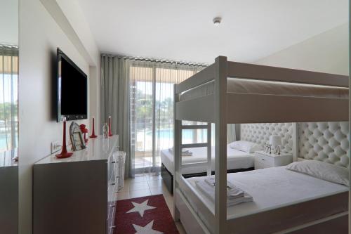 a bedroom with two bunk beds and a television at Salgados 4seasons Apartment in Albufeira