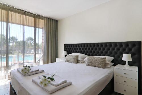 a bedroom with a large bed with a large window at Salgados 4seasons Apartment in Albufeira