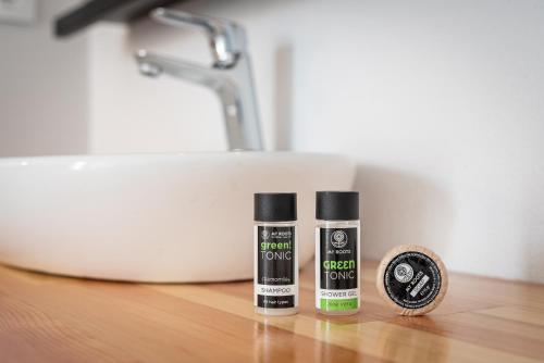 two bottles of hair products on a counter next to a sink at Mrs Chryssana Beach Hotel in Kolymvari