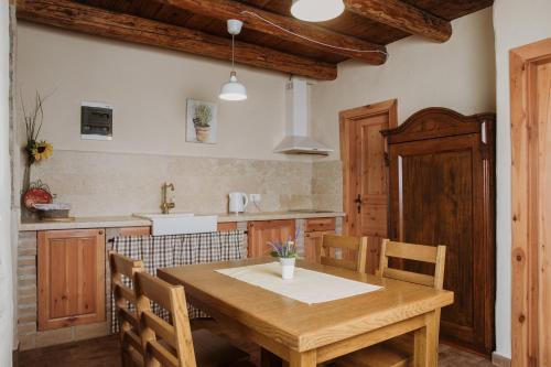 a kitchen with a wooden table and wooden chairs at Apartmaji Pajer in Koper