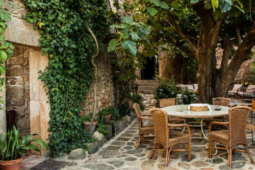 un patio al aire libre con mesa, sillas y árboles en TERRACEA, en Hoyos