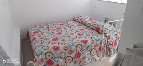 a bed with a flowered blanket on it in a room at Villa Francesca Appartamento Meraviglioso in Polignano a Mare