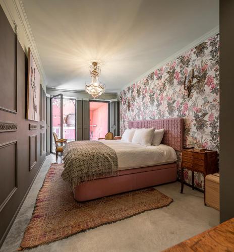 a bedroom with a large bed with floral wallpaper at toctoctoc lisboa in Lisbon