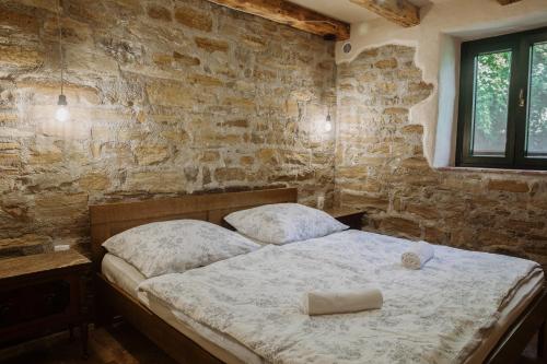 a bedroom with a bed and a brick wall at Apartmaji Pajer in Koper