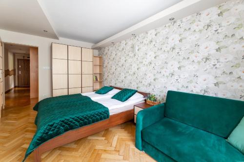 a bedroom with a bed and a couch at Apartament przy Parku in Kudowa-Zdrój