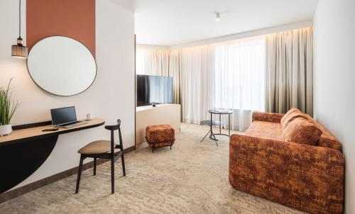 a living room with a couch and a desk at Mercure Katowice Centrum in Katowice