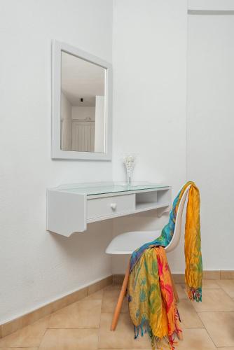 a dressing table and a chair with a mirror at Mrs Chryssana Beach Hotel in Kolymvari