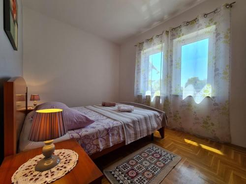 sypialnia z łóżkiem i stołem z lampką w obiekcie House Pavicini 333 w mieście Pavicini