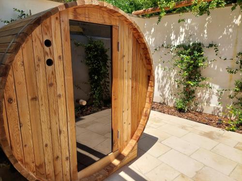 a wooden barrel door in a garden with a patio at Dimora Assuntina Martano in Martano