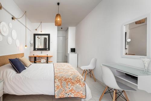 a white bedroom with a desk and a bed at Mrs Chryssana Beach Hotel in Kolymvari