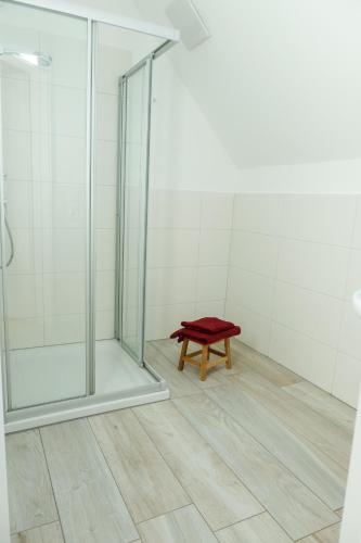 a bench with a red pillow sitting in a shower at Equiliber Reitkunstzentrum Burgenland in Wulkaprodersdorf