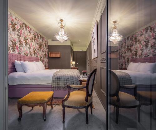 a hotel room with two beds and a table and chairs at toctoctoc lisboa in Lisbon