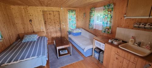 Laasi-Jaani Holiday Homes في Pamma: غرفة صغيرة بها سرير ومغسلة