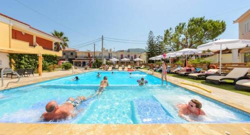 een groep mensen in een zwembad in een hotel bij Marion Holiday House in Alykes