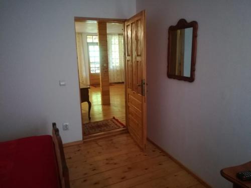 a hallway with a mirror and a wooden door at Căsuțele Doftanei in Teşila