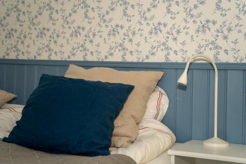 a pillow sitting on a bed next to a lamp at Svabesholms Kungsgårds B&B och Pensionat Stenshuvud in Kivik