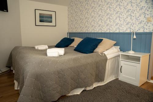 a bedroom with a large bed with blue pillows at Svabesholms Kungsgårds B&B och Pensionat Stenshuvud in Kivik