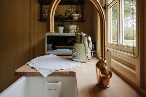 a kitchen counter with a blender and a microwave at The Shepherds Huts & The Well Lodge at Ormesby Manor in Ormesby Saint Michael