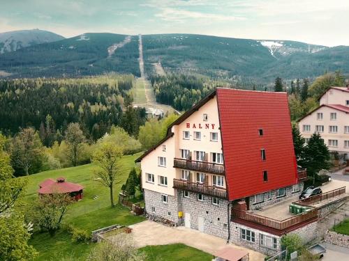a building with a red roof in a village at Halny Natura Tour in Karpacz