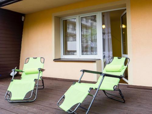 dos sillas verdes en el porche en Halny Natura Tour, en Karpacz