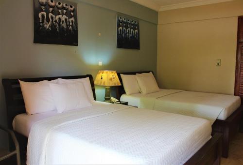 a hotel room with two beds and a lamp at Bojo Beach Resort in Bortianor