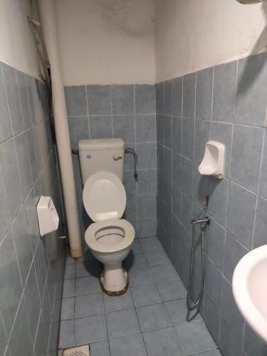 a bathroom with a toilet and a sink at ASH HOTEL in Seremban