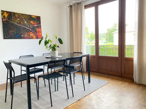 une salle à manger avec une table et des chaises noires dans l'établissement Maison chaleureuse avec un grand jardin, à La Bonneville