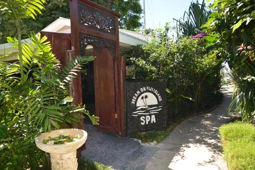 a sign for a spa in a garden at First Landing Beach Resort & Villas in Lautoka