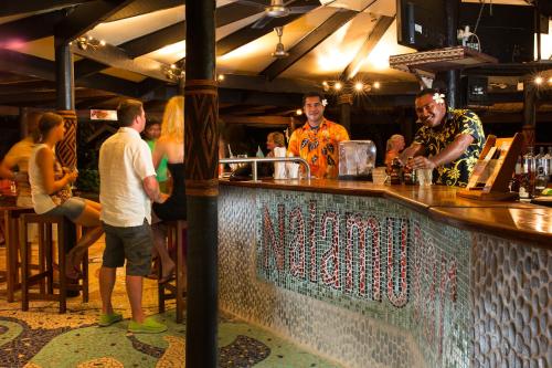 a group of people standing at a bar at First Landing Beach Resort & Villas in Lautoka