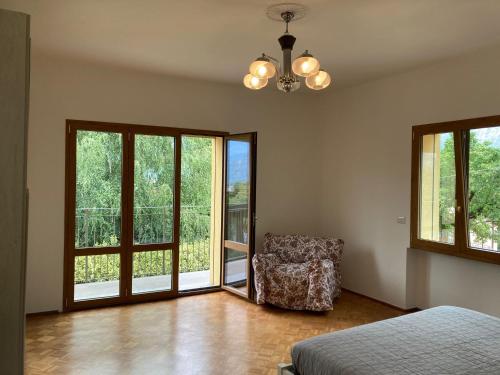 a bedroom with a bed and a chair and windows at Mati's House in Bellagio