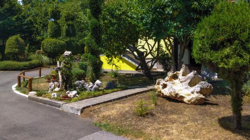 a garden with statues in the grass next to a street at Apartment Franciska in Rakovica