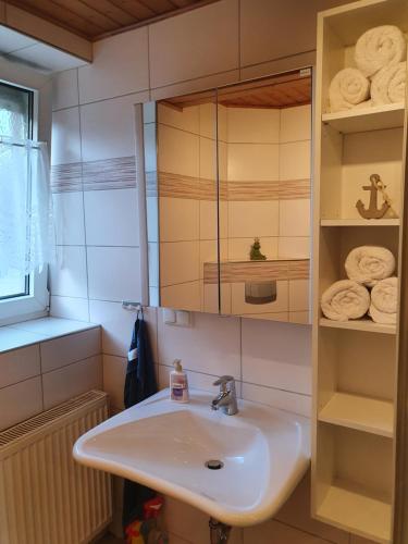 a bathroom with a sink and a mirror and towels at Schöne Ferien- Monteurswohnung - ruhig und malerisch gelegen in Hofgeismar