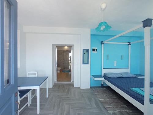 Anemos Guest House Karpathos في Olympos: غرفة نوم بسرير وجدار ازرق