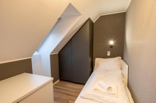 a small room with a bed and a staircase at Minaret Residence & Relax Pécs in Pécs