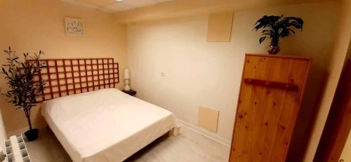 1 dormitorio con 1 cama y armario de madera en Les Papillons de la Bruche, en Dinsheim