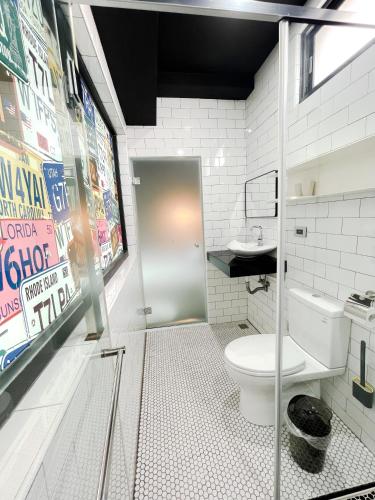 a bathroom with a toilet and a glass door at Noah's Ark Homestay in Huxi