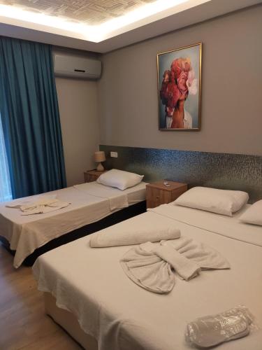 a room with two beds and a painting on the wall at Akdeniz apart hotel in Marmaris