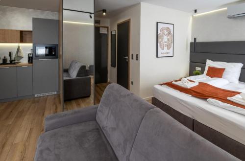 a hotel room with a bed and a couch at Minaret Residence & Relax Pécs in Pécs