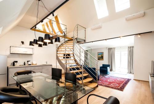 a living room with a glass table and a spiral staircase at Boutique Hotel Dom - Rooms & Suites in Graz