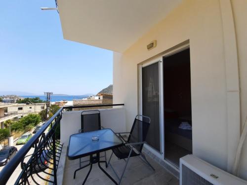 a balcony with a blue table and chairs on it at Ntemos Apartments in Tolo