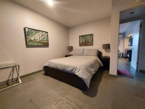 a bedroom with a bed and two pictures on the wall at Silver Box Beverly Hills in Los Angeles
